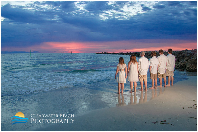 Family looking towards pink horizon on Clearwater Beach