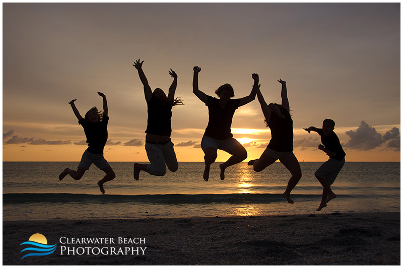 Silhouette photo of family jumping on beach